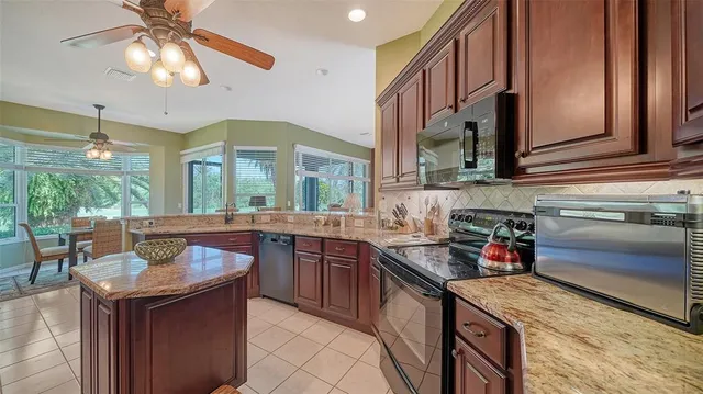 a kitchen with stainless steel appliances granite countertop a sink dishwasher stove top oven and refrigerator