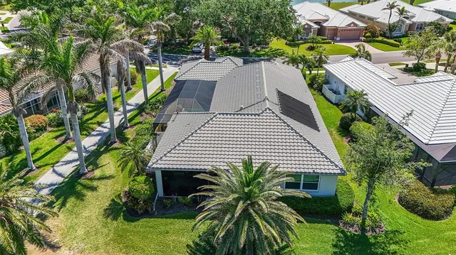 an aerial view of a house with a yard and lake view