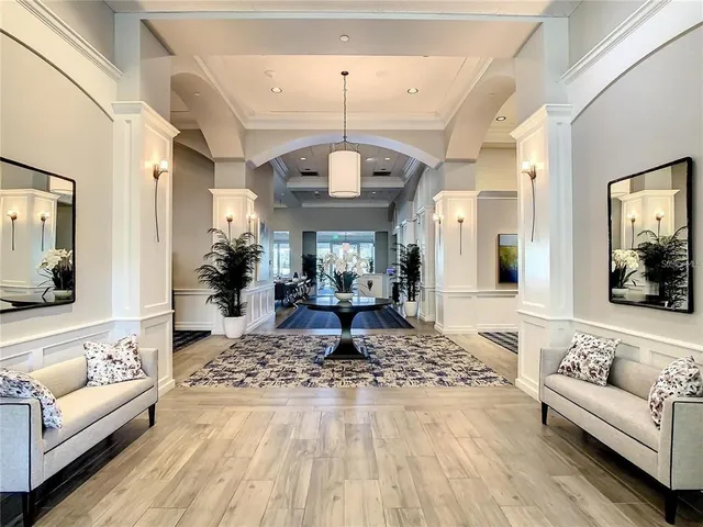 a living room with furniture a wooden floor and floor to ceiling windows