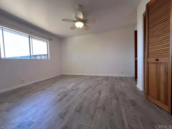 a view of empty room with wooden floor and fireplace
