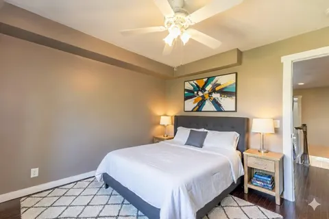 a bedroom with a bed and a painting on the wall