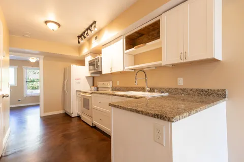 a kitchen with stainless steel appliances granite countertop a sink and a white cabinets