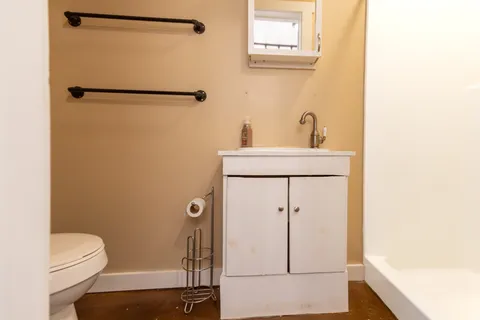 a bathroom with a toilet a sink and shower
