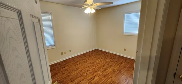 a view of empty room with window and ceiling fan