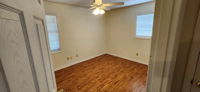 a view of empty room with window and ceiling fan