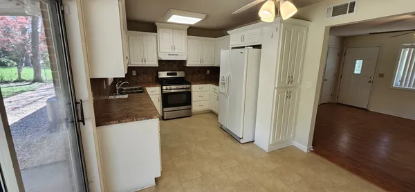 a kitchen with refrigerator and cabinets