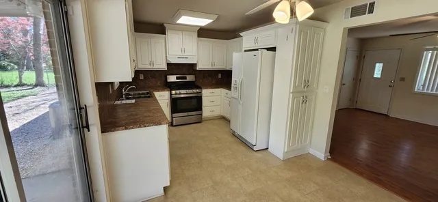 a kitchen with refrigerator and cabinets