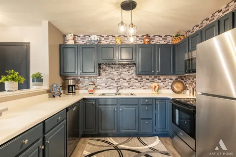 a kitchen with granite countertop a sink stainless steel appliances and cabinets