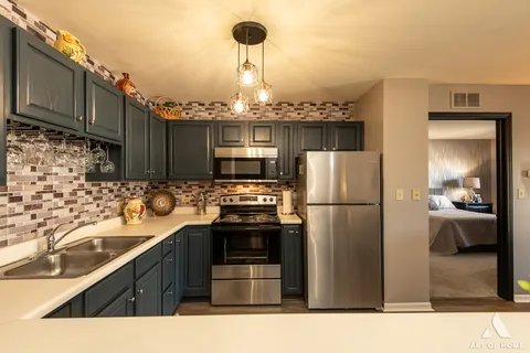 a kitchen with kitchen island granite countertop a sink appliances and cabinets