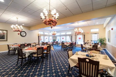 a view of a dining room with furniture a chandelier and kitchen view