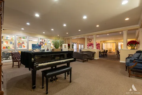 a living room with furniture a table and kitchen view