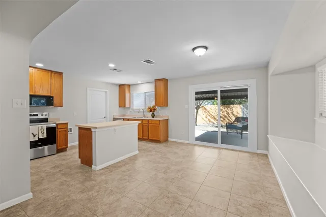 a kitchen with stainless steel appliances granite countertop a stove a sink and a microwave