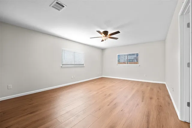 a view of an empty room with wooden floor