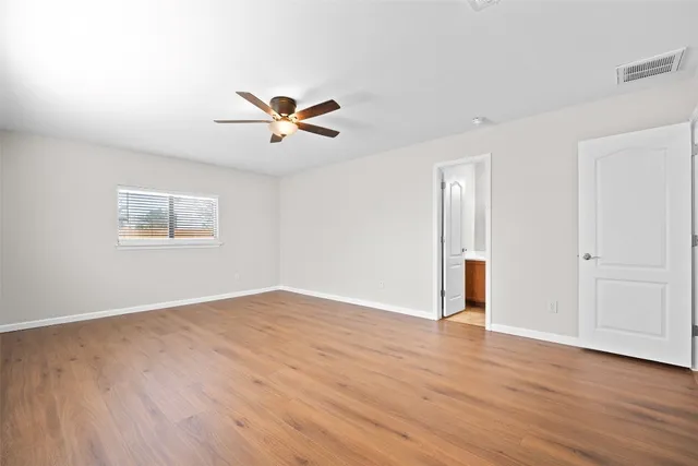 an empty room with a window and a fan