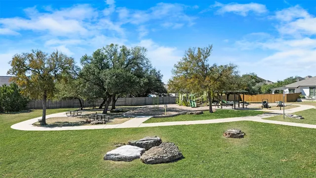 a view of a swimming pool with a bench and trees around