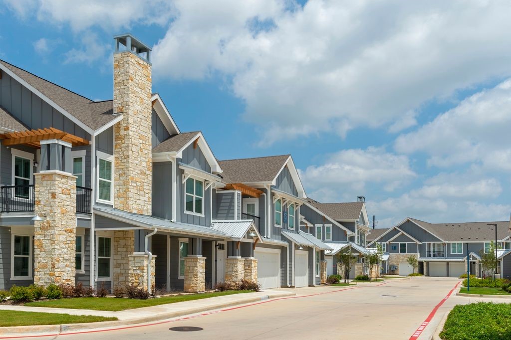 a front view of a residential apartment building with a yard