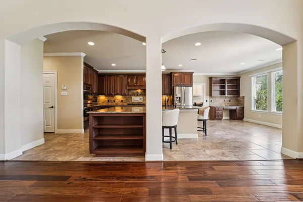 a kitchen with stainless steel appliances kitchen island granite countertop a refrigerator and cabinets