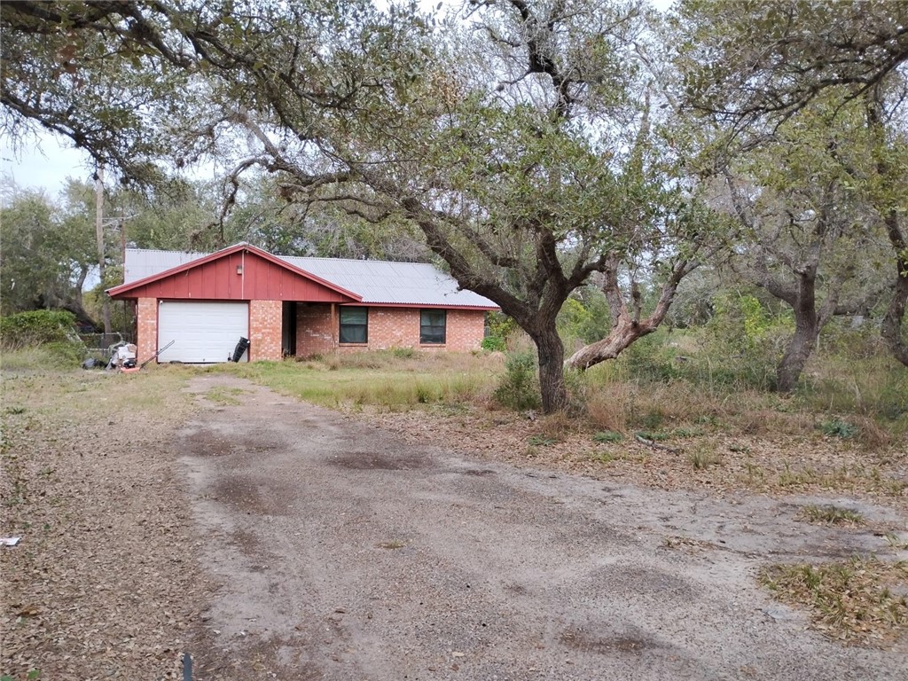 a front view of a house with yard and tree