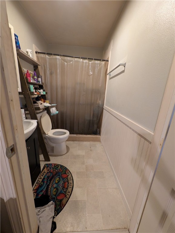 1980 Jocelyn Road Aransas Pass, TX 78336 - Photo 10 of 14 a bathroom with a sink a toilet a mirror and shower curtain