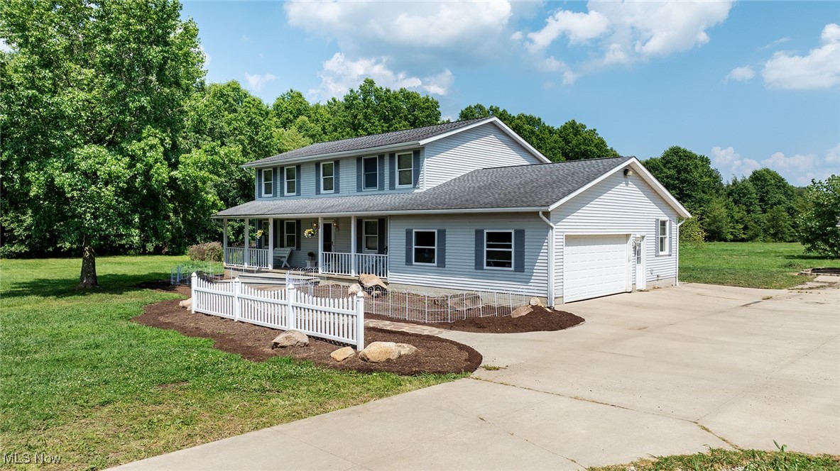 7686 Peck Road Ravenna, OH 44266 - Photo 2 of 2 View of front of property featuring a front yard, a shingled roof, covered porch, driveway, and an attached garage
