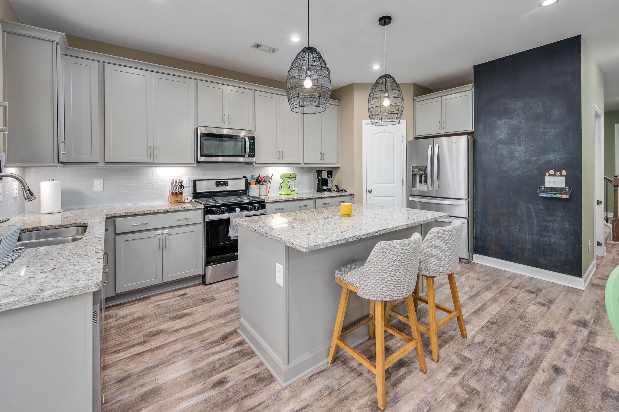 323 Disley Way Murfreesboro, TN 37128 - Photo 14 of 43 a kitchen with stainless steel appliances granite countertop a stove a sink dishwasher a refrigerator with a dining table and chairs