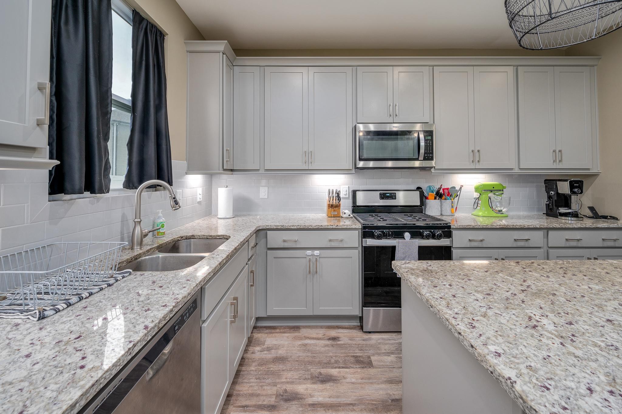 323 Disley Way Murfreesboro, TN 37128 - Photo 15 of 43 a kitchen with granite countertop a sink a stove top oven a counter space and cabinets