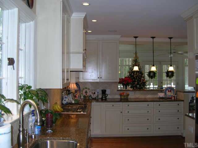 2818 Exeter Circle Raleigh, NC 27608 - Photo 5 of 10 a kitchen with stainless steel appliances granite countertop a sink a stove and a wooden floors
