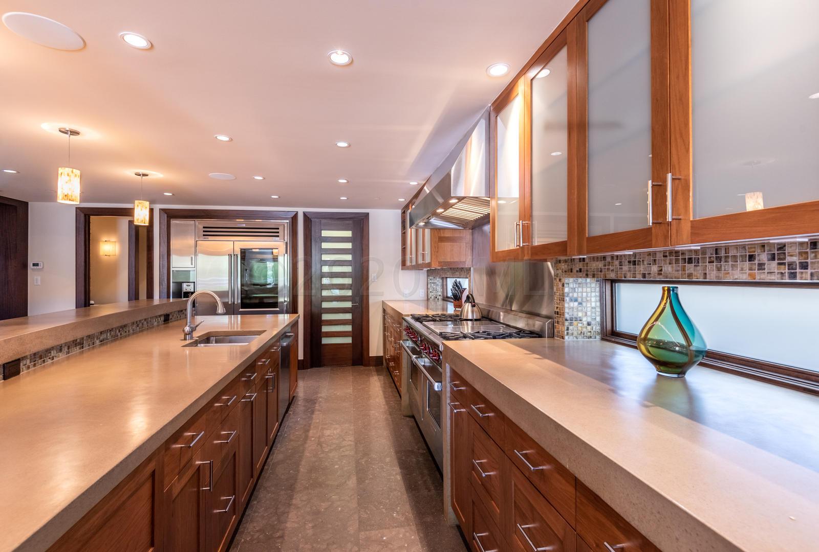 201 Gore Creek Drive, Unit R1 Vail, CO 81657 - Photo 11 of 42 a large kitchen with kitchen island a large counter top space a sink a counter top space and living room view