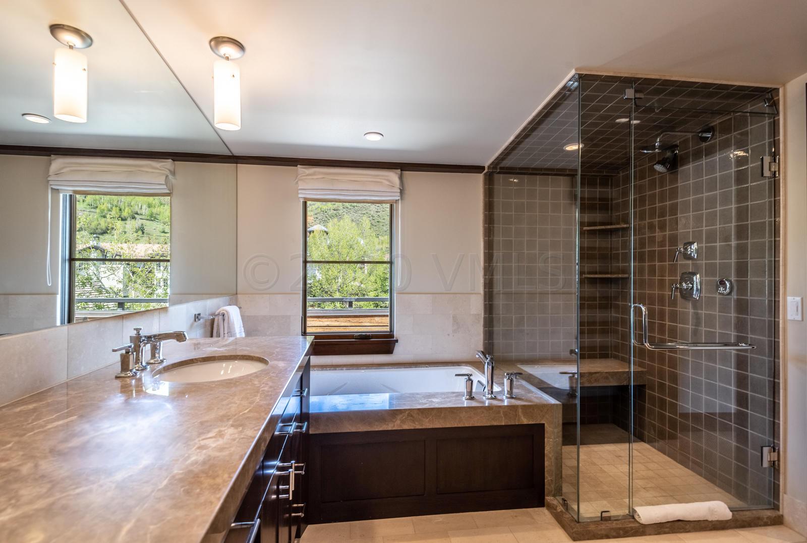 201 Gore Creek Drive, Unit R1 Vail, CO 81657 - Photo 21 of 42 a bathroom with a granite countertop sink a bathtub and window