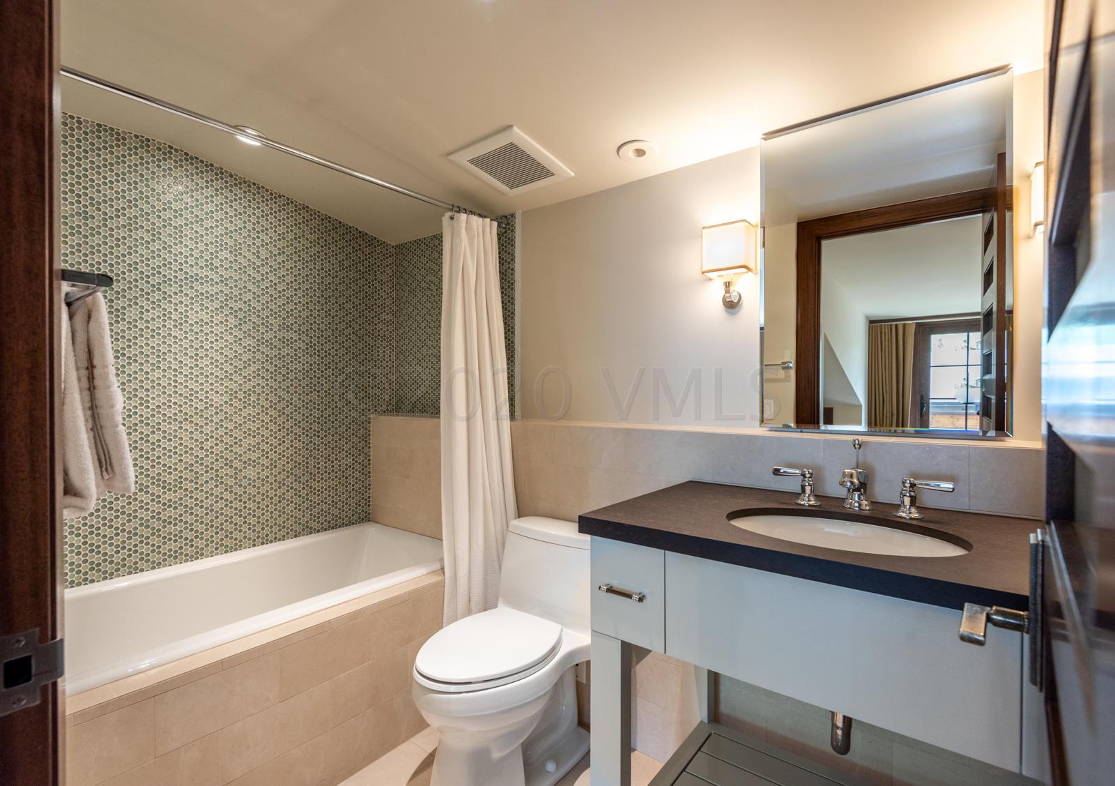 201 Gore Creek Drive, Unit R1 Vail, CO 81657 - Photo 25 of 42 a bathroom with a granite countertop sink mirror toilet and bathtub