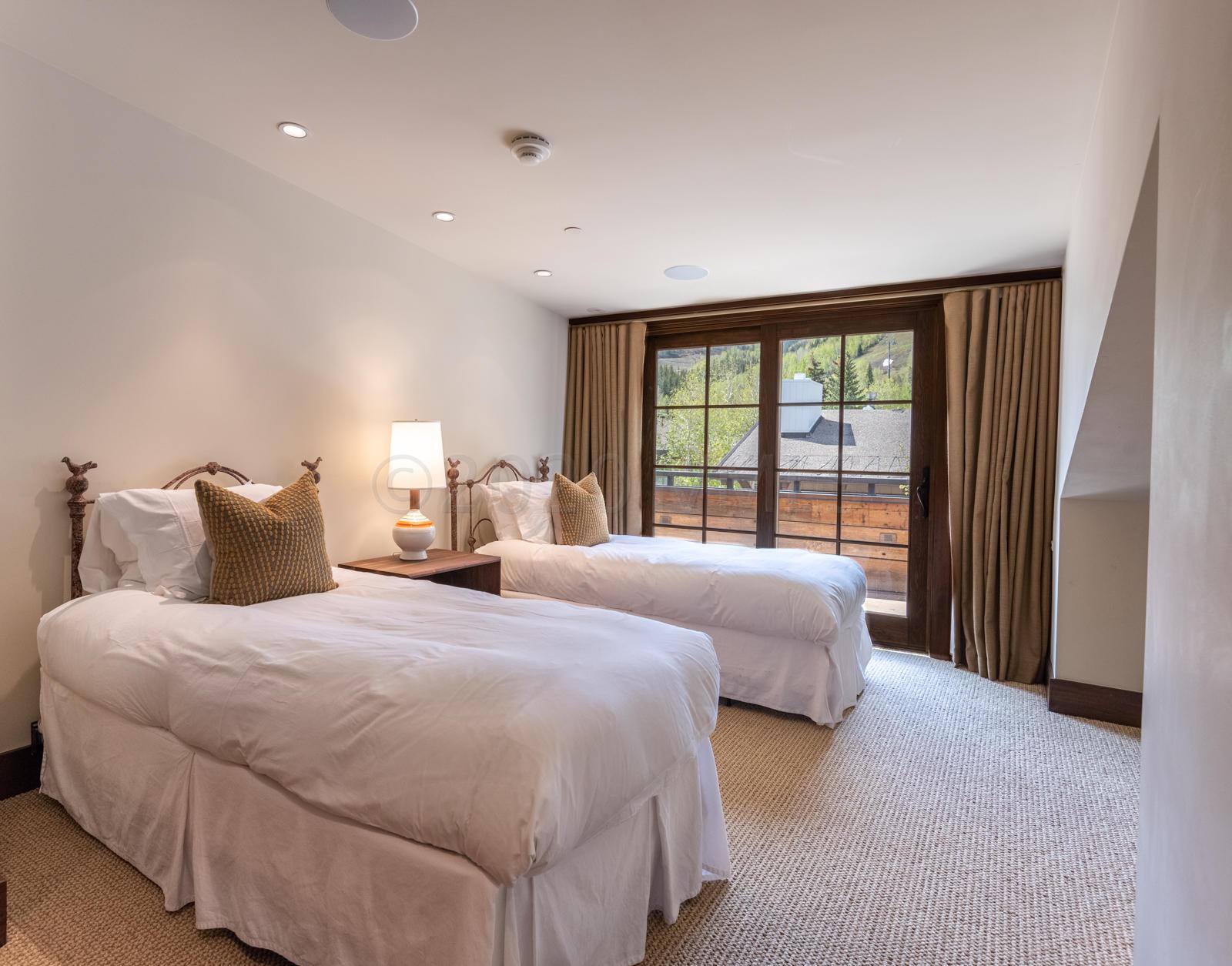 201 Gore Creek Drive, Unit R1 Vail, CO 81657 - Photo 28 of 42 a bedroom with two beds and a large window