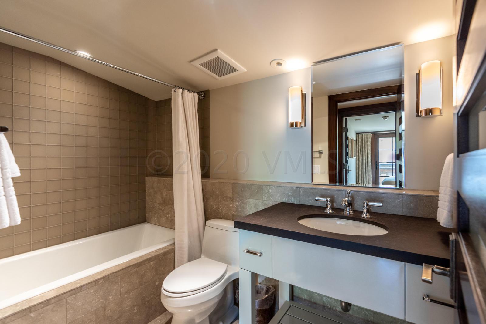 201 Gore Creek Drive, Unit R1 Vail, CO 81657 - Photo 30 of 42 a bathroom with a sink a toilet a mirror a bathtub and shower