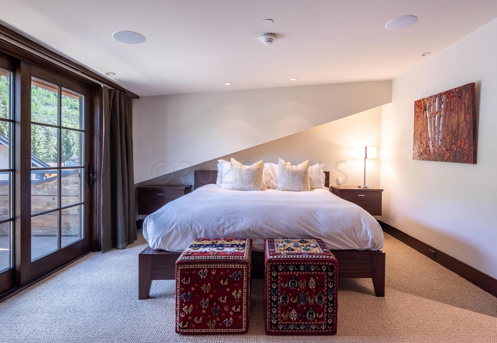 201 Gore Creek Drive, Unit R1 Vail, CO 81657 - Photo 31 of 42 a bedroom with a bed a mirror and a large window