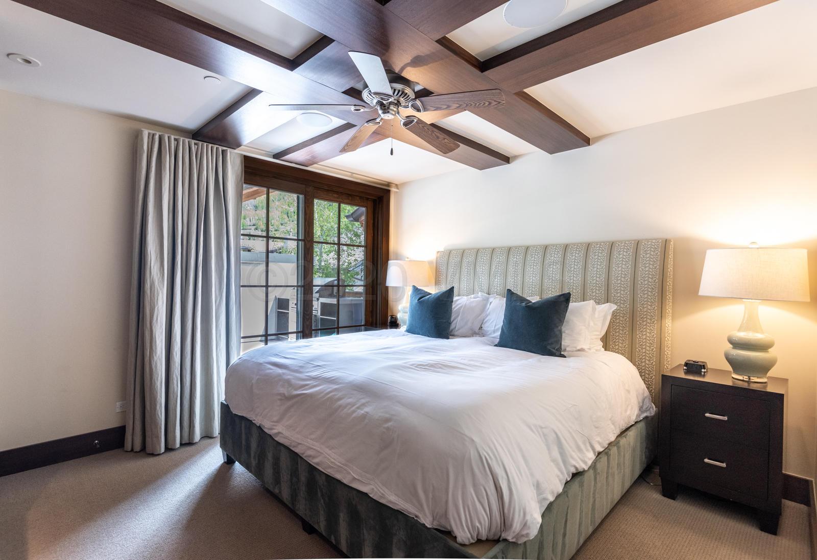 201 Gore Creek Drive, Unit R1 Vail, CO 81657 - Photo 35 of 42 a bedroom with a large bed and a chandelier