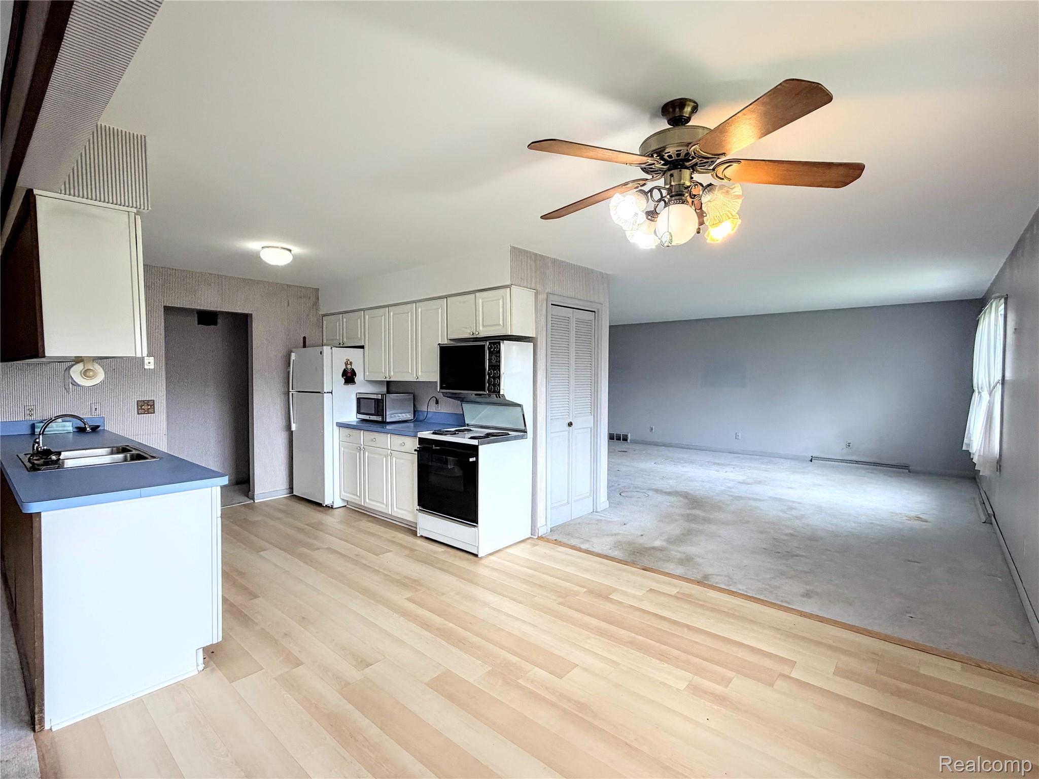 8079 Farley Road Pinckney, MI 48169 - Photo 12 of 43 Kitchen featuring white appliances, white cabinets, a ceiling fan, and light wood-type flooring