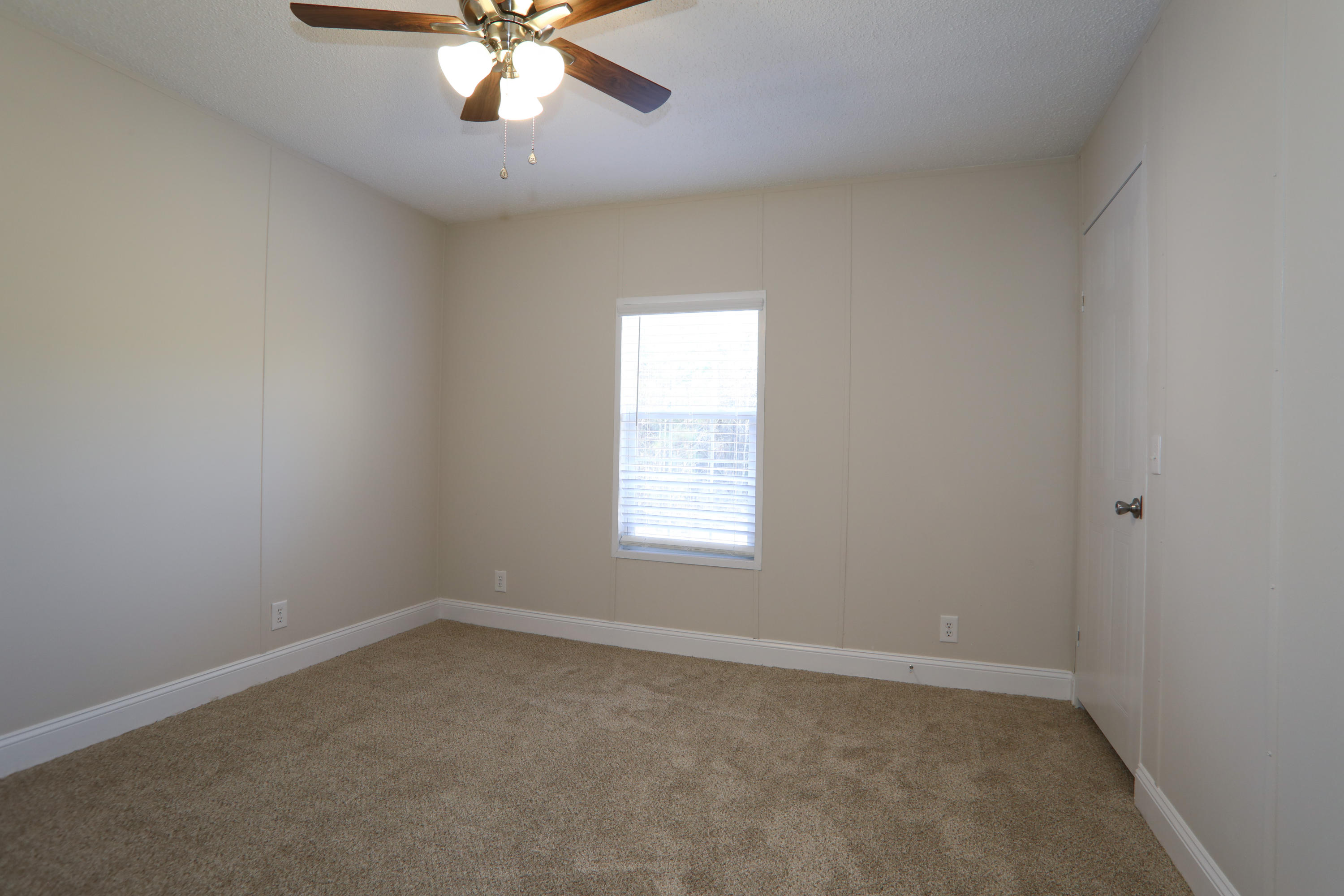 2080 West Kelley Road Baker, FL 32531 - Photo 16 of 20 an empty room with a window and a fan
