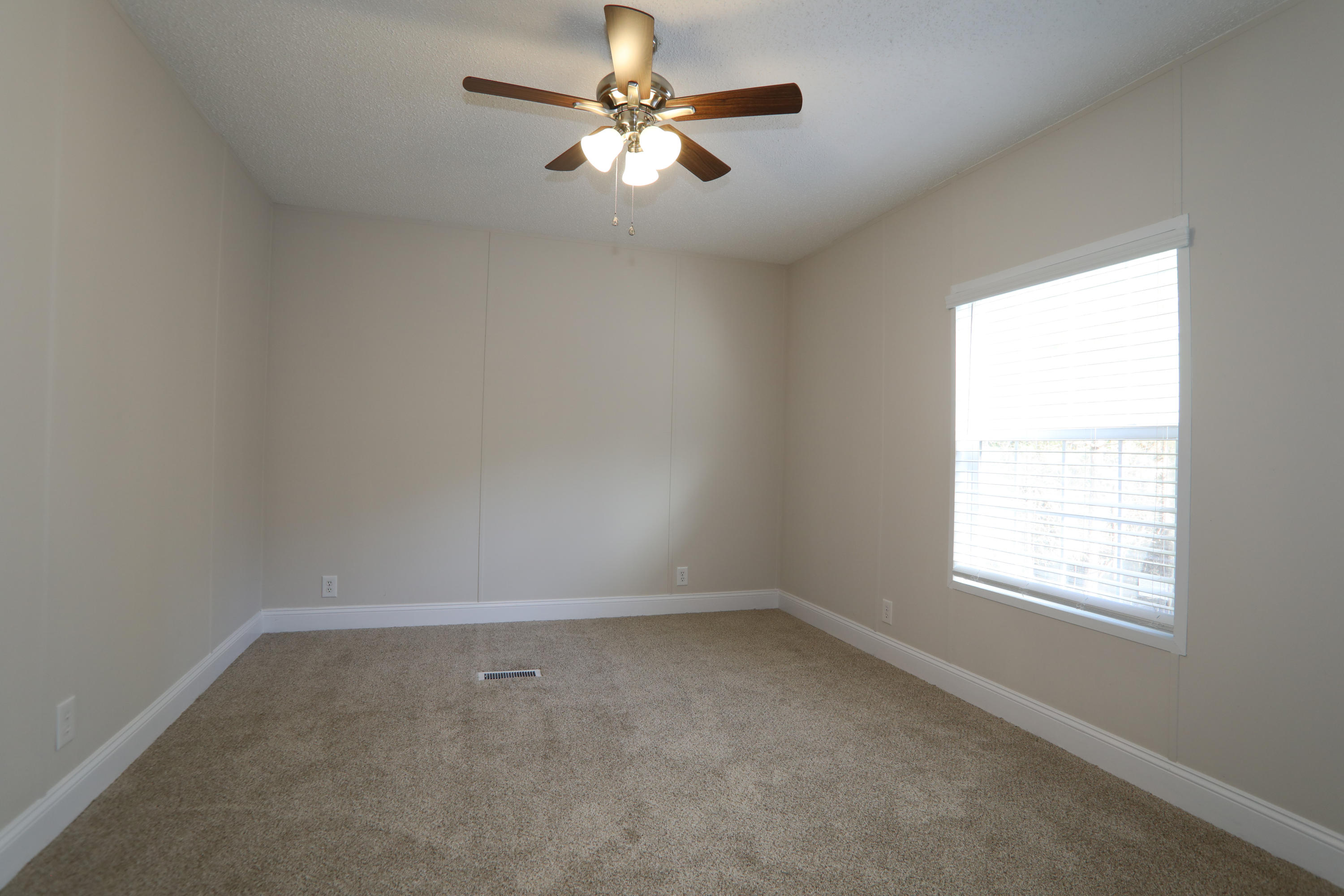 2080 West Kelley Road Baker, FL 32531 - Photo 18 of 20 an empty room with a window and a fan