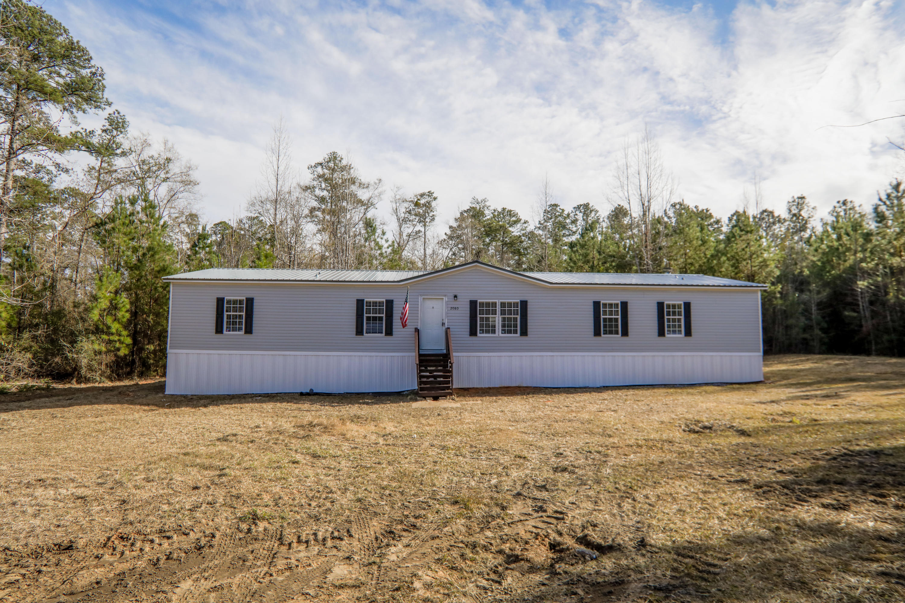 2080 West Kelley Road Baker, FL 32531 - Photo 3 of 20 a house that is sitting in the grass with large trees