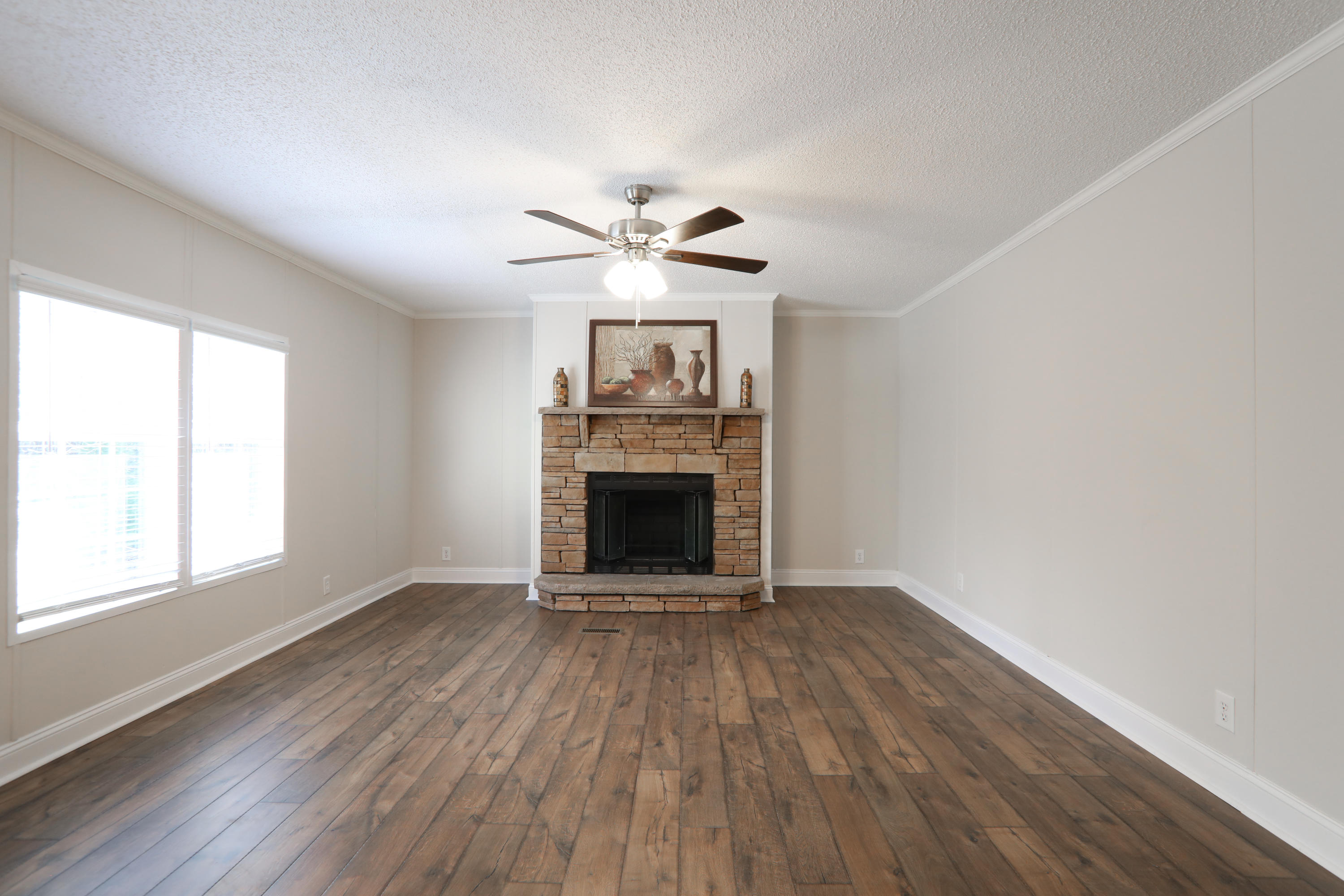 2080 West Kelley Road Baker, FL 32531 - Photo 7 of 20 an empty room with a fireplace and a ceiling fan
