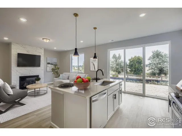 a kitchen with a stove a sink a counter space and living room view