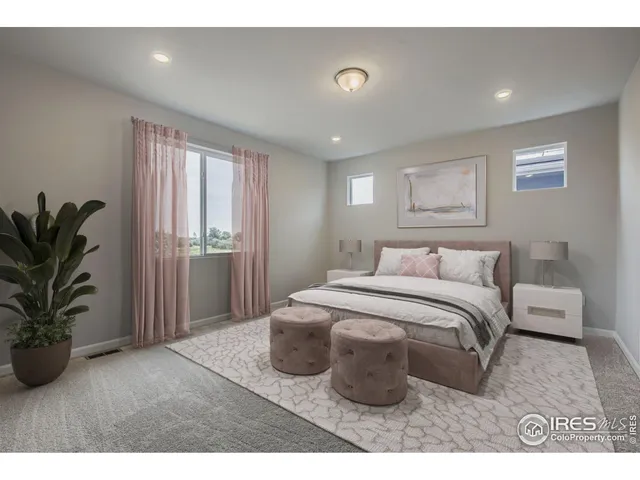 a spacious bedroom with a bed and a potted plant