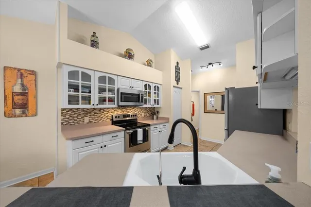 a kitchen with stainless steel appliances white cabinets and a stove top oven