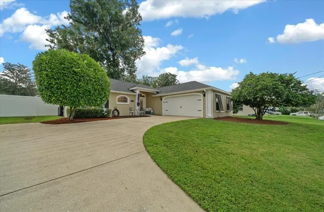 a front view of a house with a yard and trees