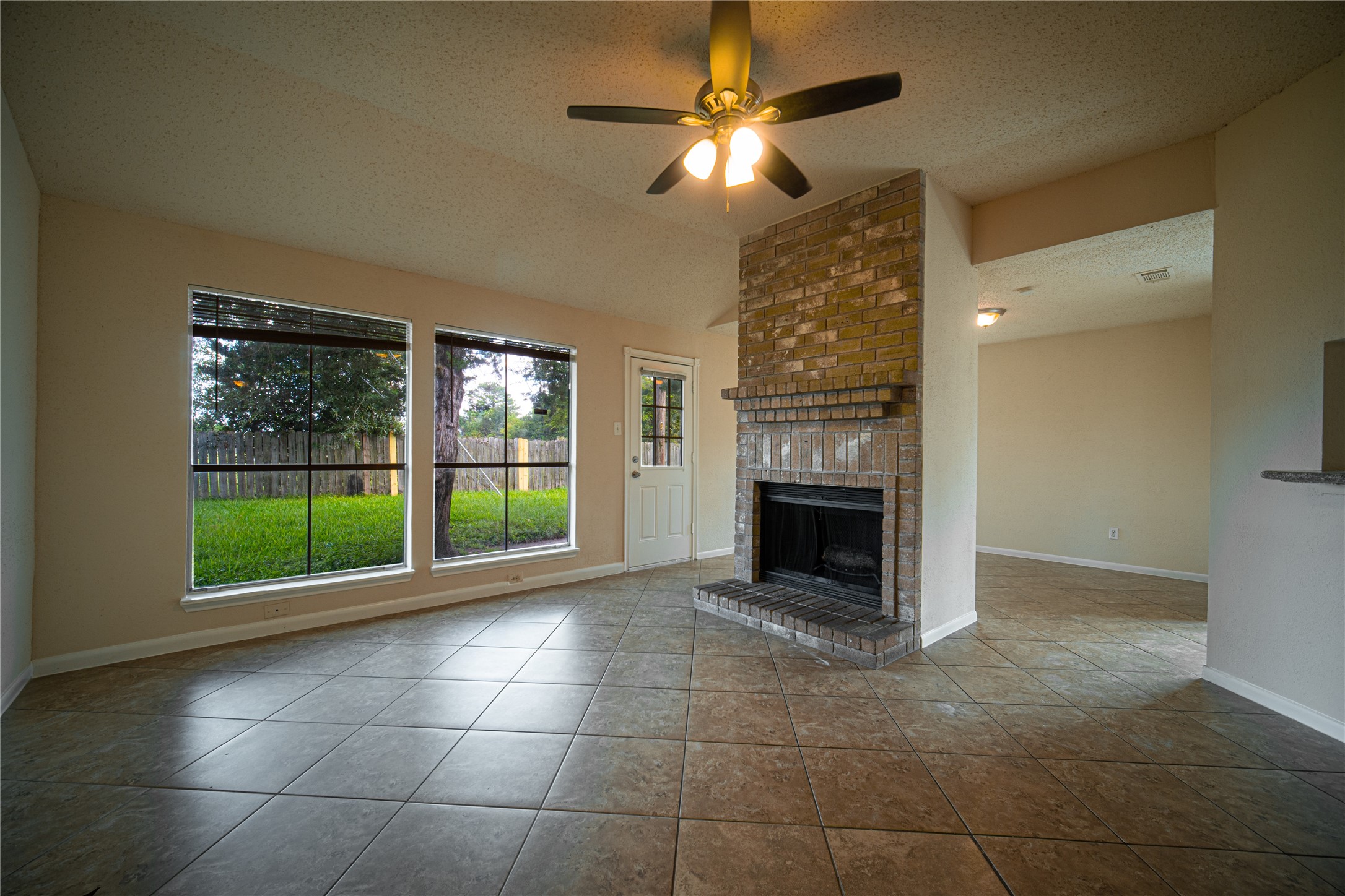 13314 Sablewood Lane Houston, TX 77014 - Photo 2 of 12 a view of an empty room with a fireplace and a window