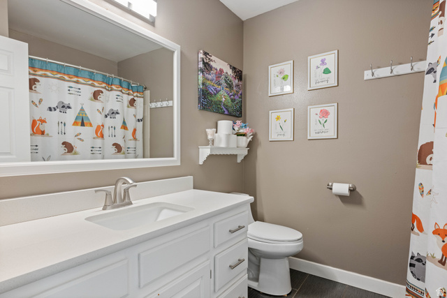 790 East Fiddlers Canyon Road Cedar City, UT 84721 - Photo 20 of 35 Bathroom featuring a white vanity with an integrated sink, brushed nickel faucet, large framed mirror, and dark tile flooring