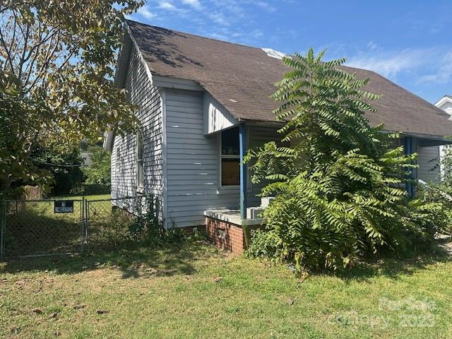 407 Florence Street Clinton, SC 29325 - Photo 2 of 3 a backyard of a house with plants and large trees