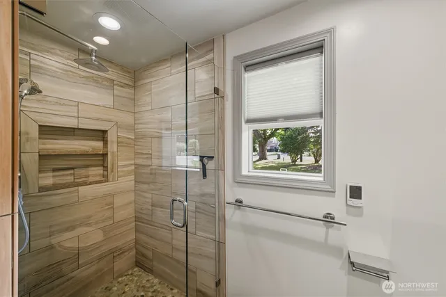 a bathroom with a window and a shower