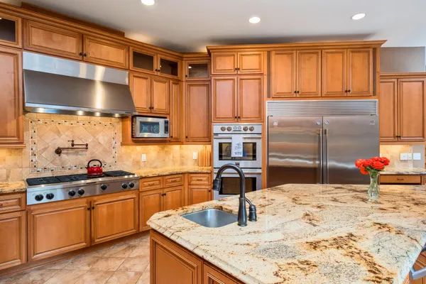 a kitchen with stainless steel appliances kitchen island granite countertop a sink stove and cabinets