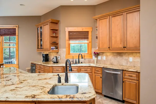 a kitchen with stainless steel appliances granite countertop a sink a stove and a microwave oven