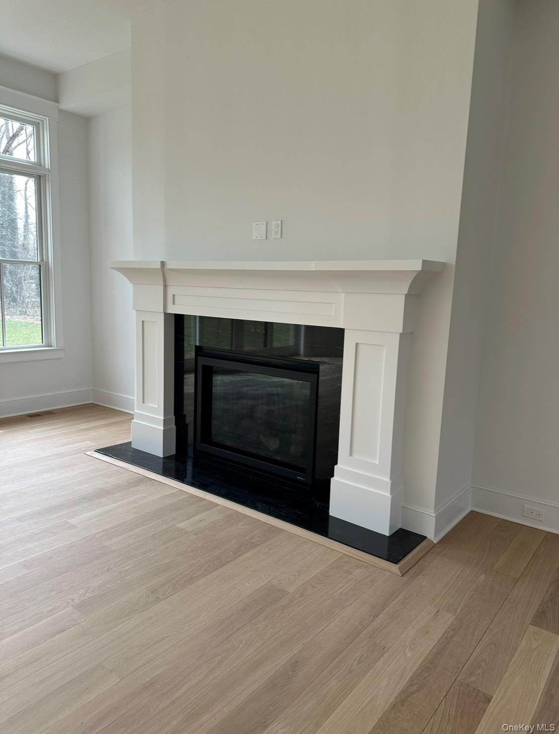 97 Aspatuck Road Westhampton Beach, NY 11978 - Photo 11 of 49 a view of empty room with wooden floor and fireplace